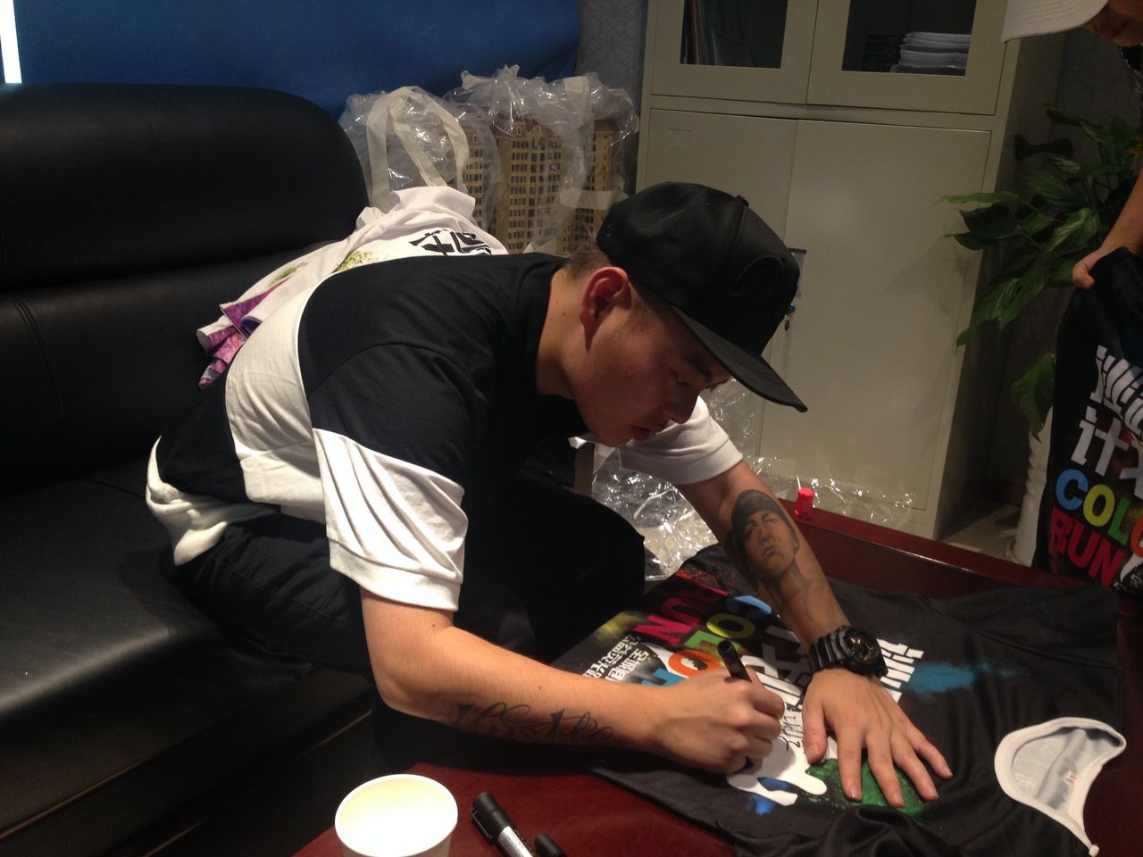 Fat Shady signs autographs backstage before a show in Luzhou.