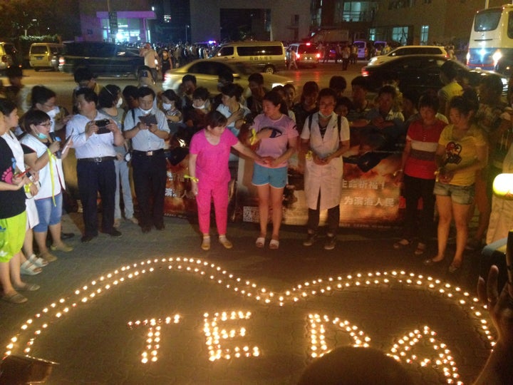 Volunteers, victims and family members gather for a candlelight vigil on Thursday night.The blast occurred in the Teda development zone of Tianjin.