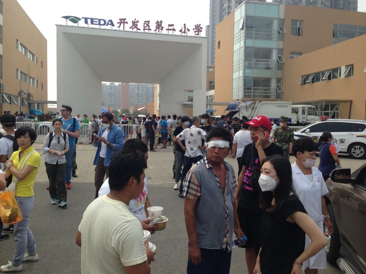 Victims and volunteers gather outside a shelter near the site of the blast. 