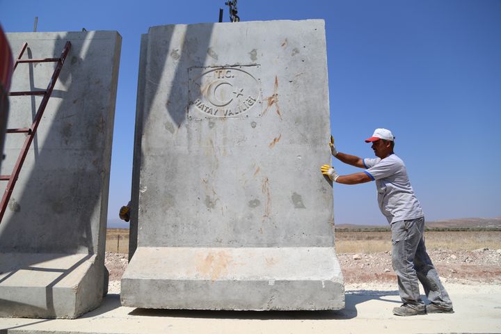 A worker builds the wall between the Turkish-Syrian border in Hatay, Turkey, on Aug. 13, 2015.