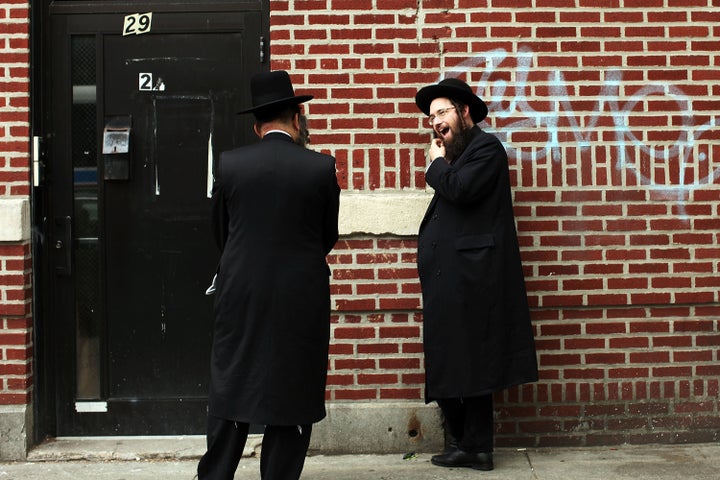 Members of the Jewish Orthodox community talk on a street in a Brooklyn neighborhood on June 14, 2012 in New York City.