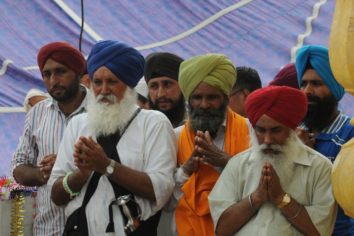 Sikh pilgrims offer prayers at a Sikh shrine in Lahore on June 29, 2013.