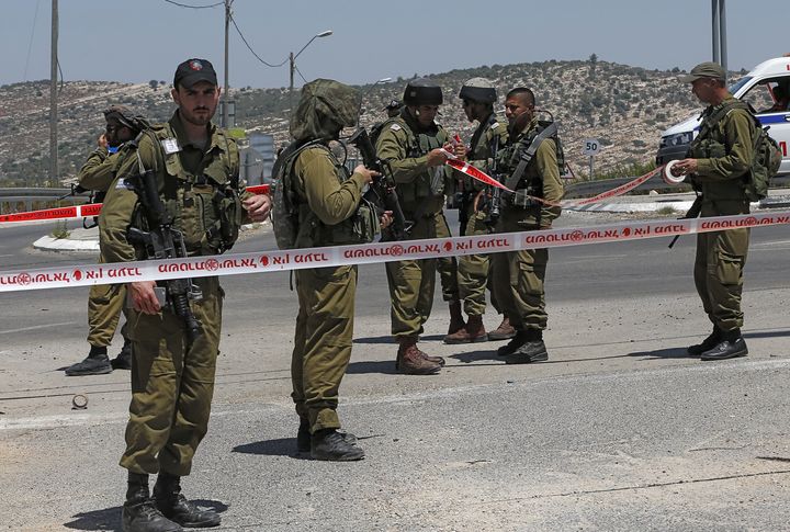 Israeli security forces stand in a security perimeter at the site where a Palestinian young man was shot by Israeli troops after he had stabbed a soldier on Aug. 15, 2015 near the West Bank village of Beit Ur.
