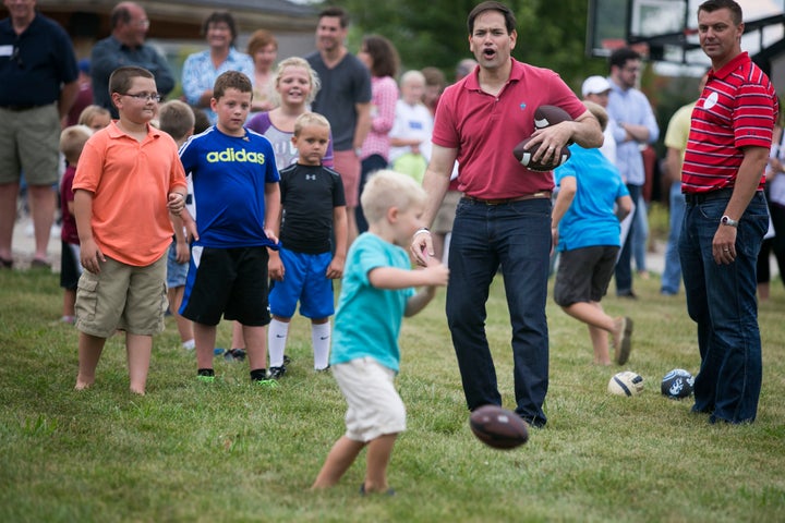 Republican presidential hopeful Sen. Marco Rubio (R-Fla.) reacts as a child fails to catch a football during a Family Night e