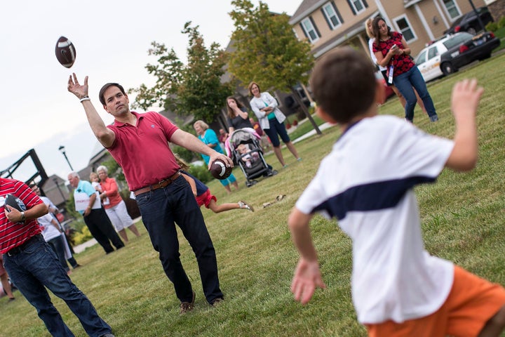Republican presidential candidate Sen. Marco Rubio (R-Fla.) throws a football with children during a Family Ni