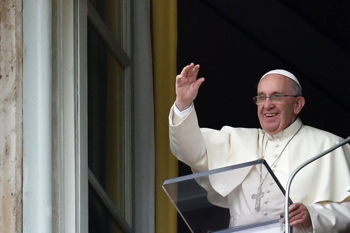 Pope Francis waves to faithfuls gathered in St. Peter's Square following his Sunday Angelus prayer from the window of the pontiff studio on August 16, 2015 at the Vatican. 