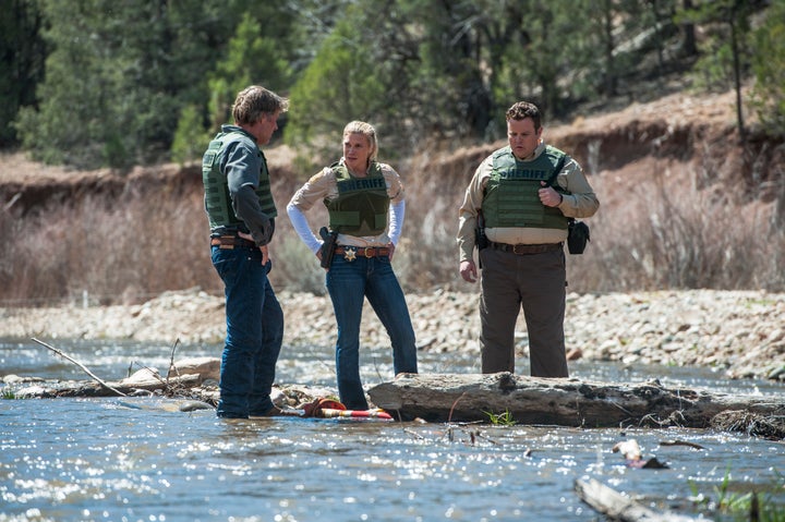 Sheriff Walt Longmire (Robert Taylor) and his deputies, Vic Moretti (Katee Sackhoff) and The Ferg (Adam Bartley), investigate a crime scene.