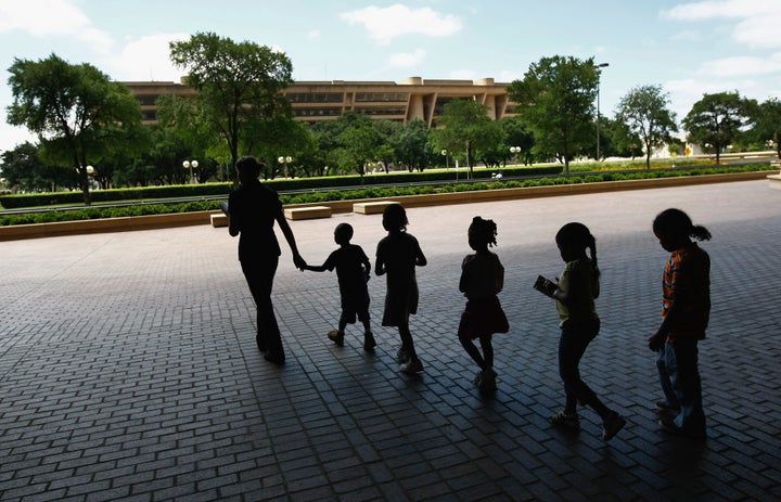 Homeless children are led to lunch at a soup kitchen on June 17, 2009 in Dallas, Texas. 