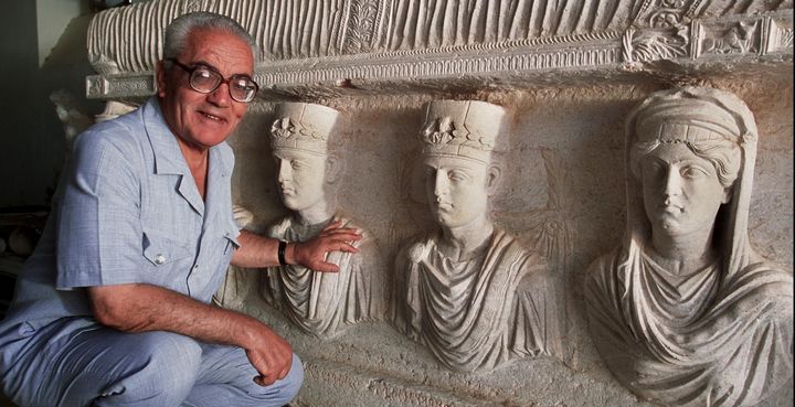 <p>Khaled Asaad poses in front of a rare, 1st-century sarcophagus in Palmyra. Asaad was killed this week by ISIS. </p>