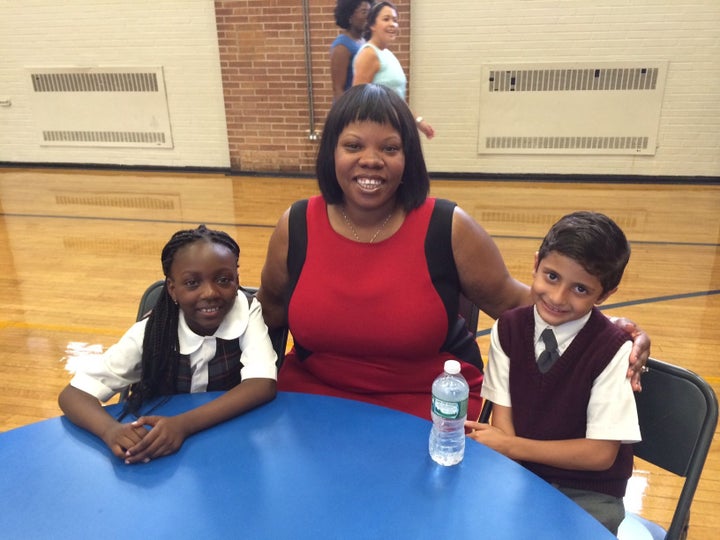 Aleeya Francis, principal of St. Charles Borromeo School in Harlem, sits with students Farida Mintoumba (left) and Essa Nahshal.