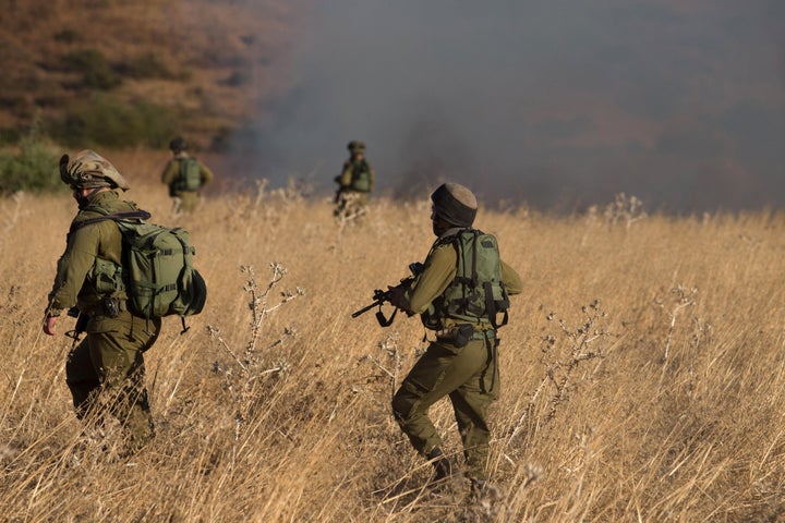 Israeli soldiers inspect a field where rockets fired from Syria landed near Kfar Szold in northern Israel, close to the Golan Heights and the border with Lebanon, on Aug. 20, 2015.