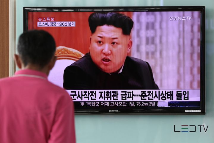 A man looks at a television screen showing an image of Kim Jong Un, leader of North Korea.