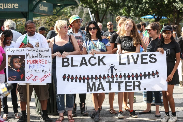 Protesters march behind a banner of "Black Lives Matter" on August 9 in New York, one year after the death of unarmed black t
