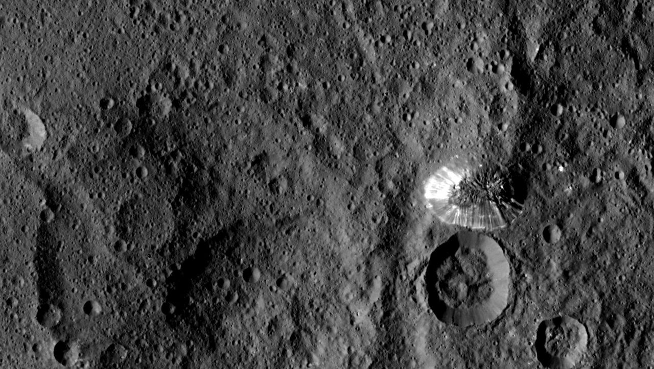 <p>Ceres' four-mile tall mountain is seen toward the center right of this photograph, taken by NASA's Dawn spacecraft on Aug. 19, 2015. </p>