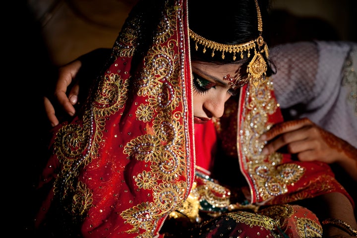 15-year-old Nasoin Akhter is consoled by a friend on the day of her wedding to a 32-year-old man, Aug. 20, 2015 in Manikganj, Bangladesh.