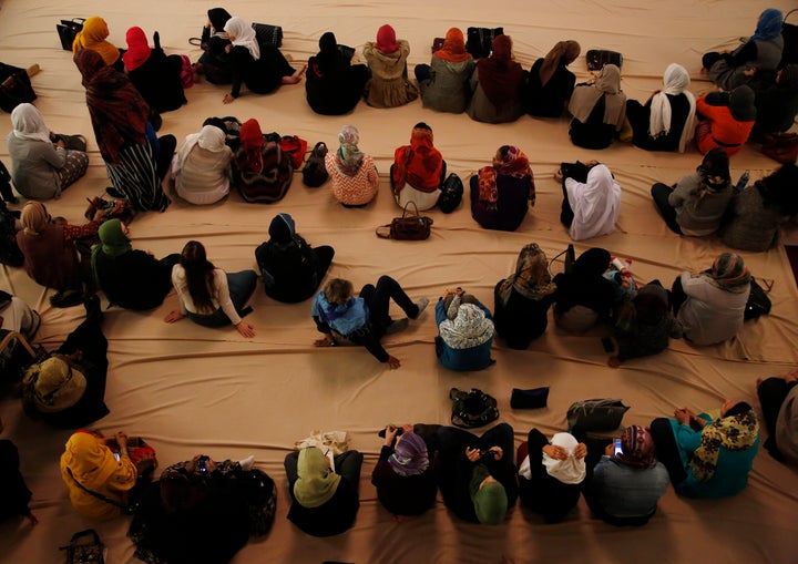 Muslim women prepare to pray during the service at the Masjid Al-Abidin mosque December 6, 2002 in the Queens borough of New York City.