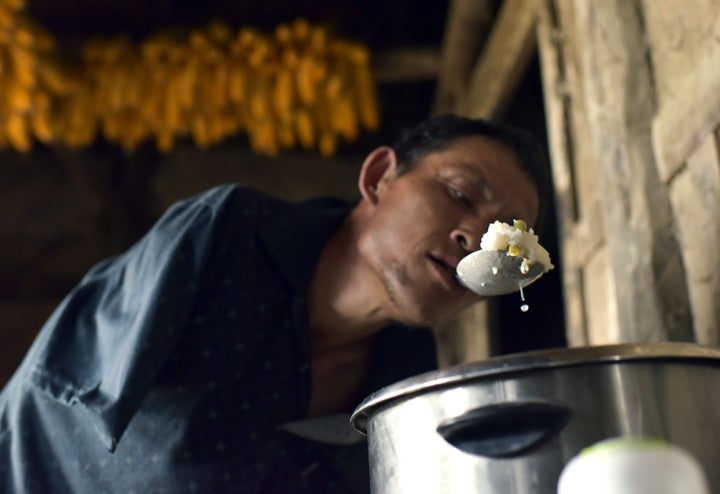 Chen Xingyin holds a spoon in the mouth to fill a bowl with rice.