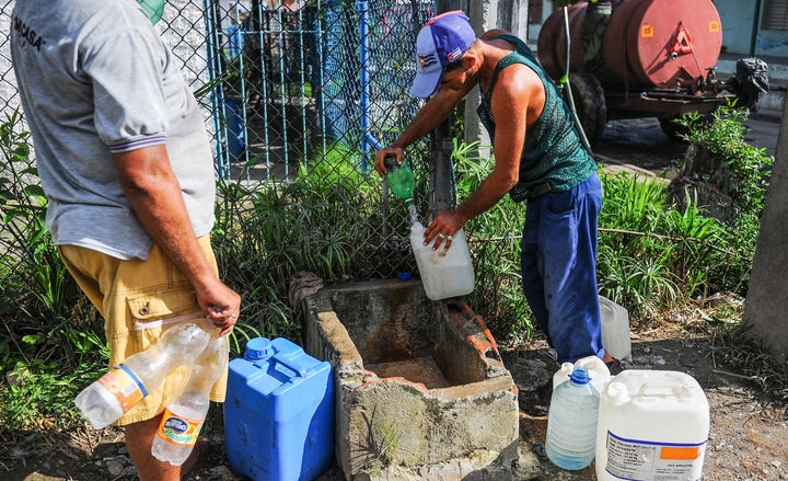 A man fills bottles with water in the Consolacion del Sur neighborhood in the Pinar del Rio province, Cuba on August 19, 2015.