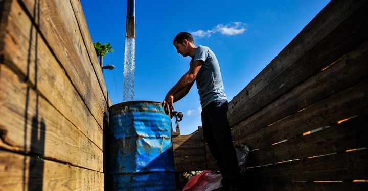 <p>A man fills a drum with water in the Consolacion del Sur neighborhood in the Pinar del Rio province, Cuba on August 19, 2015.</p>