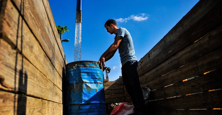 A man fills a drum with water in the Consolacion del Sur neighborhood in the Pinar del Rio province, Cuba on August 19, 2015.