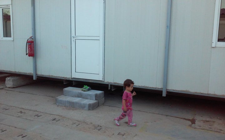 A child walks next to a temporary housing unit in the Eleonas camp in Athens, Greece. 