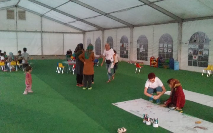 Children play at the children's tent in the Eleonas camp as their mothers look on. 