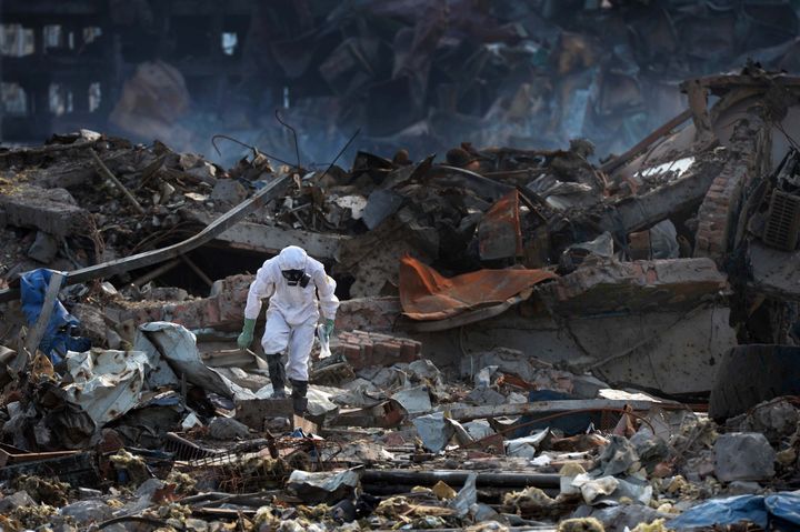 A police officer wearing a chemical suit searches for missing men at the scene of the explosion in Tianjin, China, on Aug. 25, 2015.