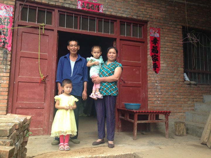 Liu Qiaoyun (right) poses with her husband and two granddaughters. The family received weekly visits from family planning officials who taught them parenting techniques.