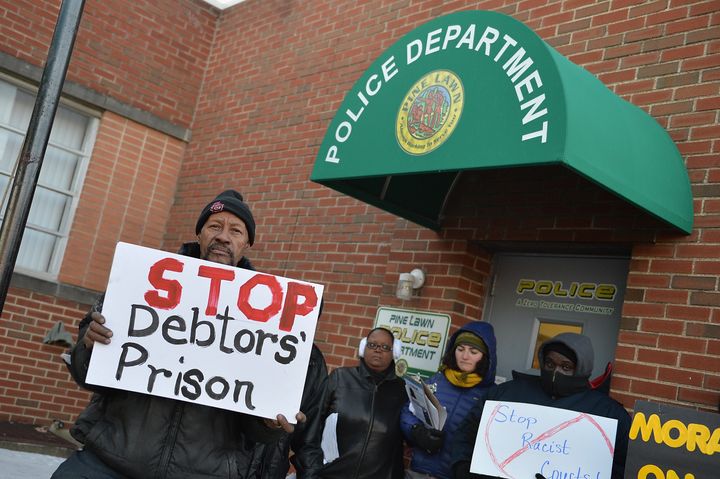 Demonstrators protest outside the police department entrance of the Pine Lawn Municipal Court Building on March 5, 2015, in Pine Lawn, Missouri. Nearby Wellston is one of several towns suing in response to a law that decreases how much money small municipalities can make from petty fines.
