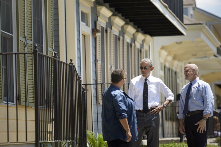 President Barack Obama (C) and New Orleans Mayor Mitch Landrieu (R) talk with a woman during a tour of the Treme neighborhood