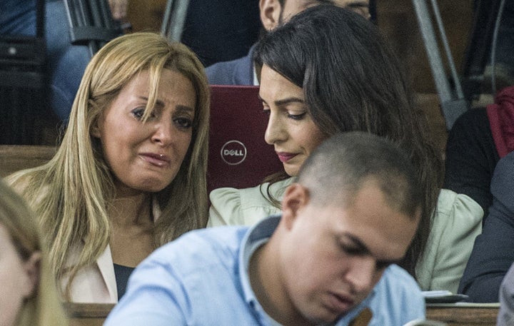 Marwa Fahmy (L), the wife of Canadian Al-Jazeera journalist Mohamed Fahmy (unseen), reacts as she sits next to Amal Clooney,
