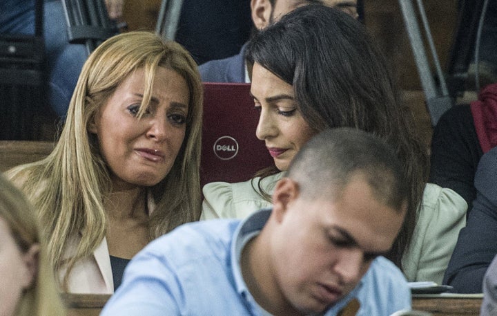 Marwa Fahmy (L), the wife of Canadian Al-Jazeera journalist Mohamed Fahmy (unseen), reacts as she sits next to Amal Clooney, the human rights lawyer representing Fahmy, during the trial of her husband and Egyptian Baher Mohamed, both accused of supporting the blacklisted Muslim Brotherhood in their coverage for the Qatari-owned broadcaster, on August 29, 2015, in the capital Cairo. 