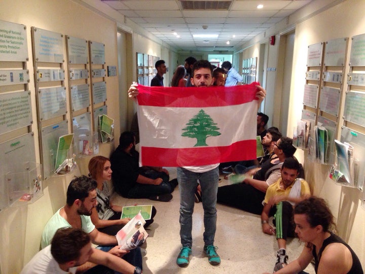 Lebanese activist holds a national flag in a hallway during a sit-in at Lebanon's environment ministry in Beirut on Sept.1, 2