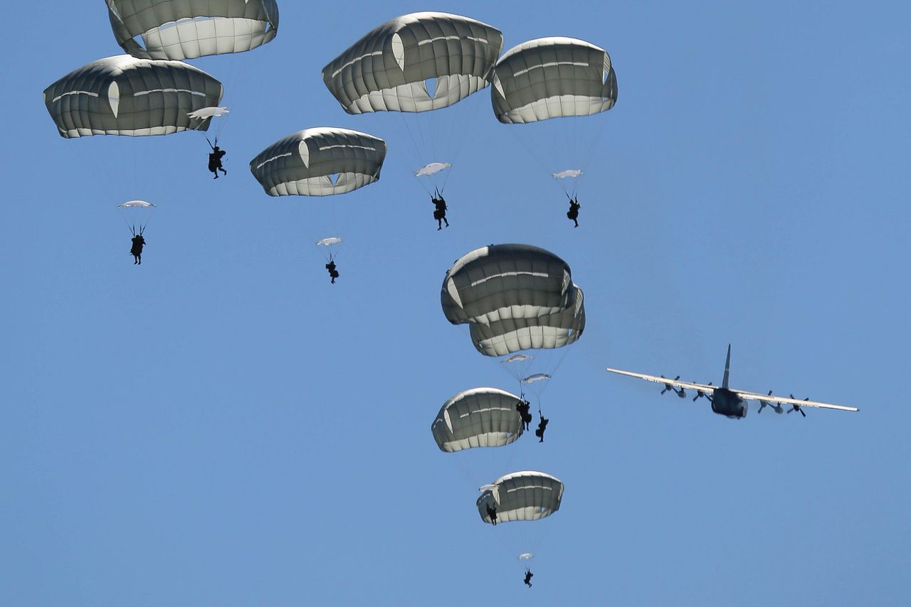 Paratroopers assigned to 1st Battalion (Airborne), 501st Infantry Regiment descend after jumping out of a C-130 Hercules, assigned to the 374th Wing from Yokota Air Base, Japan, over the Malemute drop zone at Joint Base Elmendorf-Richardson, Alaska, Aug. 24, 2015. 