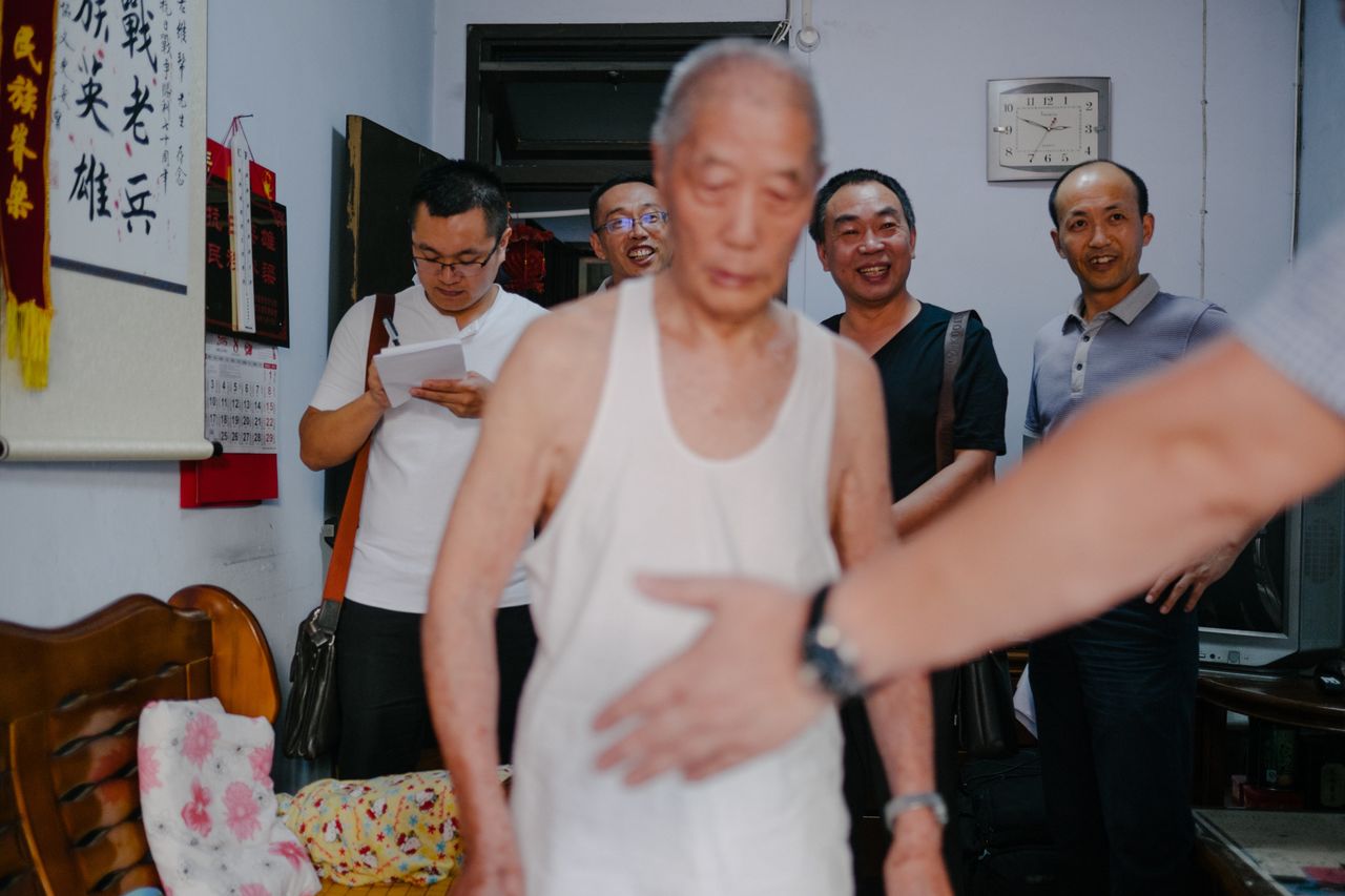 <p>Local officials visit Zheng Weibang to check if he is healthy enough to travel to Beijing. He will receive a medal of honor from President Xi Jinping.</p>