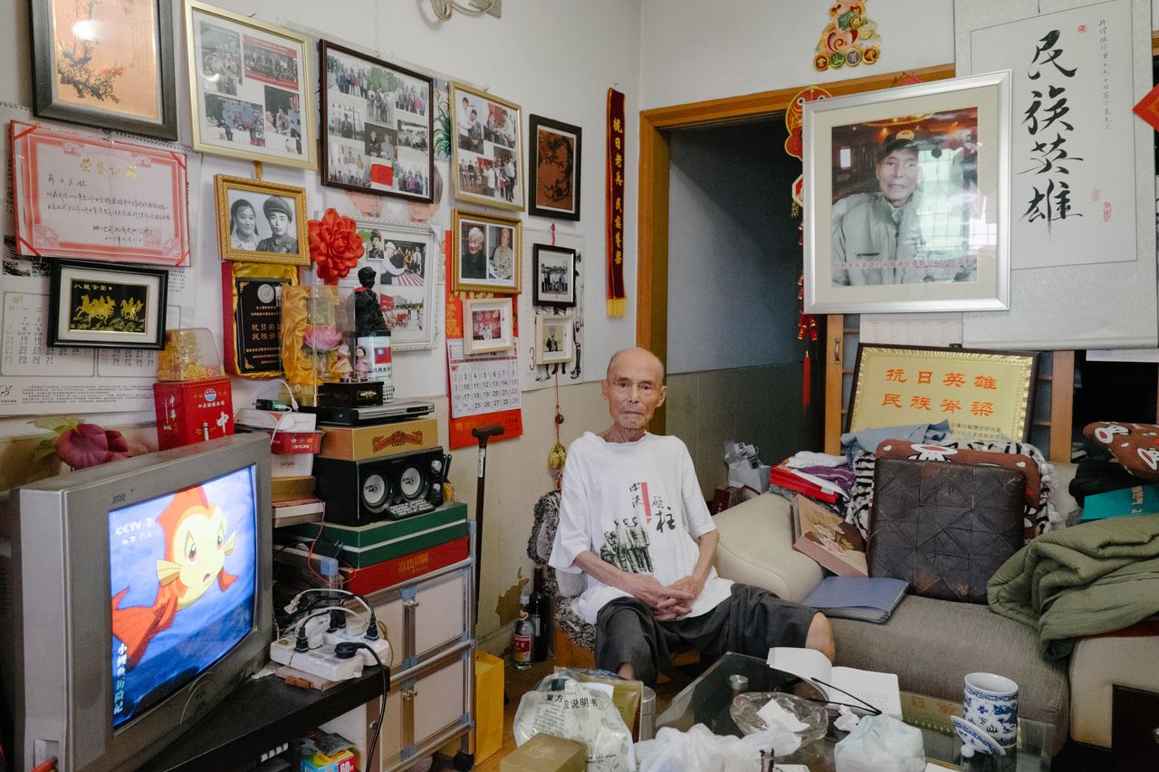 On the walls of Su's living room in Chengdu hang photos and certificates commending his service. 