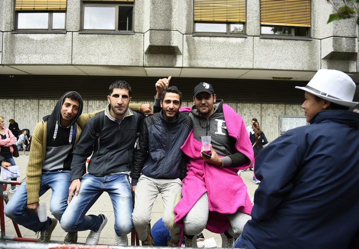 Syrian refugees queue outside outside the State Office of Health and Social Affairs in Berlin (LAGeSo) where hundreds of migrants wait to receive help from the Berlin administration on August 25, 2015. 