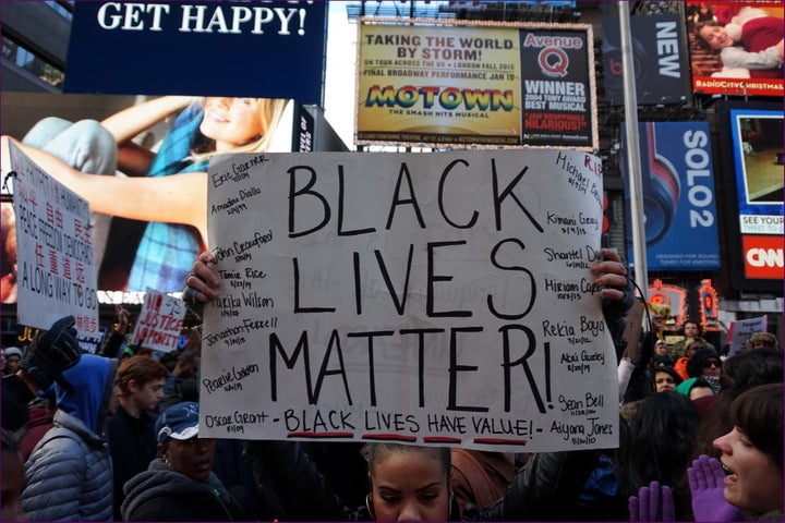 <p>A Black Lives Matter protester holds up a sign during a march in New York City.</p>