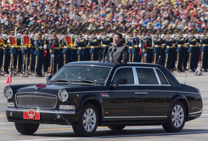 Chinese president and leader of the Communist Party Xi Jinping rides in an open top car in front of Tiananmen Square and the
