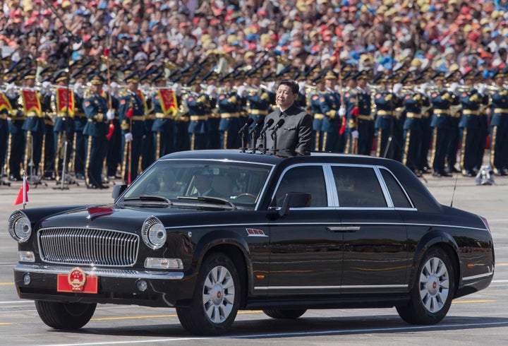 Chinese president and leader of the Communist Party Xi Jinping rides in an open top car in front of Tiananmen Square and the Forbidden City.