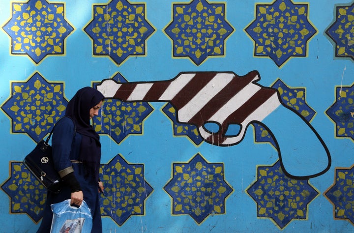 A woman walks past graffiti in Tehran on Sept. 2, 2015.