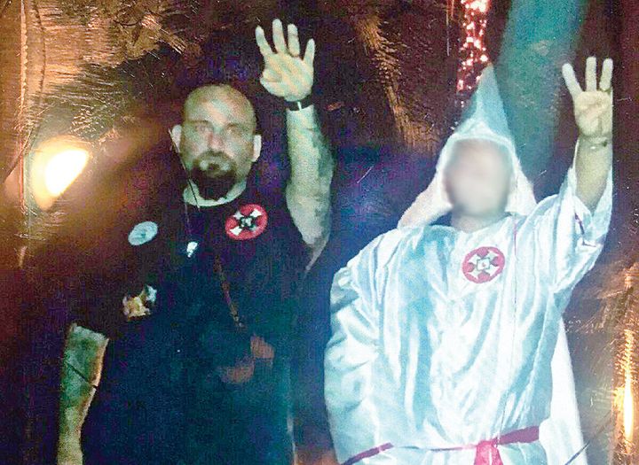 In this photo from the Jennings Daily News, Raymond Mott, left, is seen giving a Nazi salute at a Ku Klux Klan rally.
