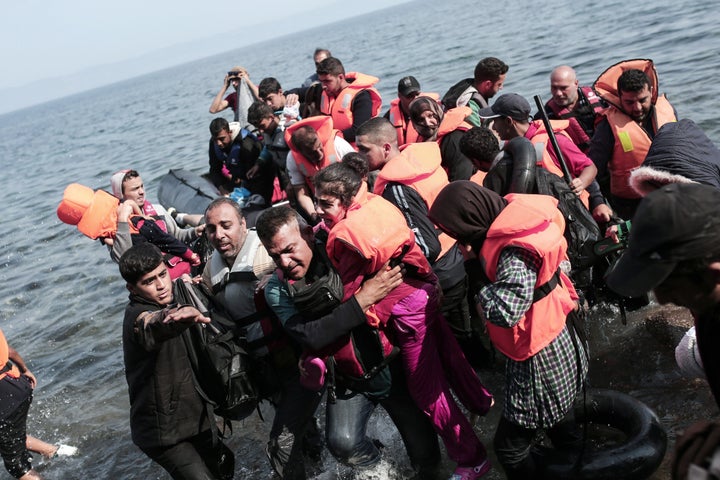 Syrian refugees land on the shores of the Greek island Lesbos in an inflatable dingy across the Aegean Sea from Turkey on September 3, 2015.