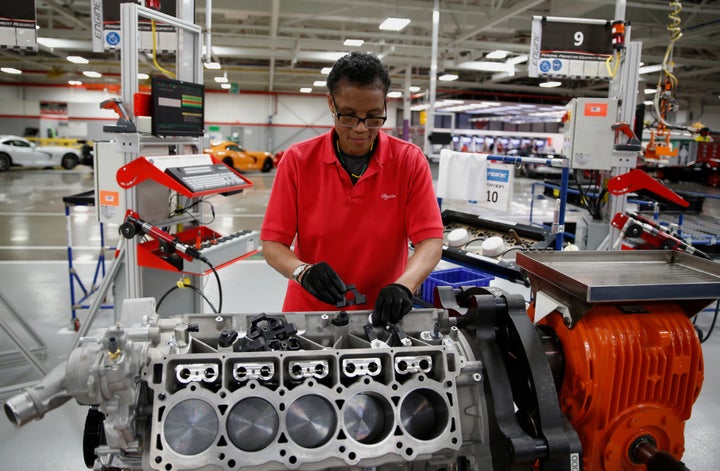 A Fiat Chrysler employee works on a 2015 Dodge Viper car engine at a Detroit, Michigan factory in May 2015. Economists d