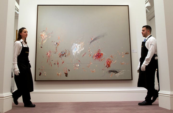 Sotheby's employees walk past a newly-discovered painting by Cy Twombly during the Sotheby's Impressionist, Modern & Contemporary Art auctions press preview in London on January 29, 2014. (ANDREW COWIE/AFP/Getty Images)