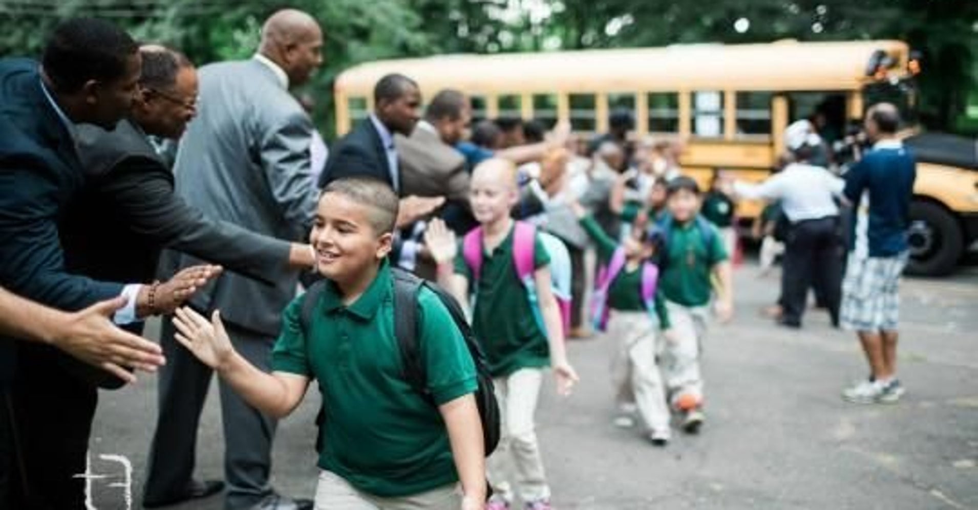 group-of-100-black-male-professionals-greet-students-on-first-day-help