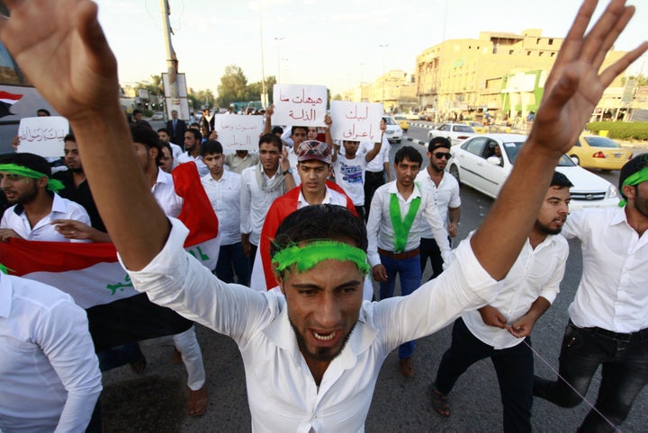 Iraqi men take part in a demonstration to show their support for the call to arms by Shiite cleric Grand Ayatollah Ali al-Sistani, in the central Shiite Muslim shrine city of Najaf on June 13, 2014. 