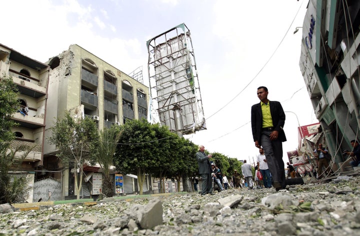 A Yemeni man walks past damaged buildings following air-strikes by the Saudi-led coalition in the capital Sanaa on Sept. 5, 2