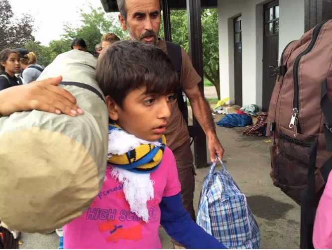 A young Syrian boy and his dad make their way towards the train to Vienna. 