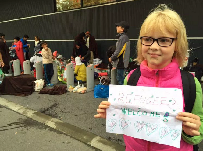 A young Austrian girl welcomes refugees to Vienna.